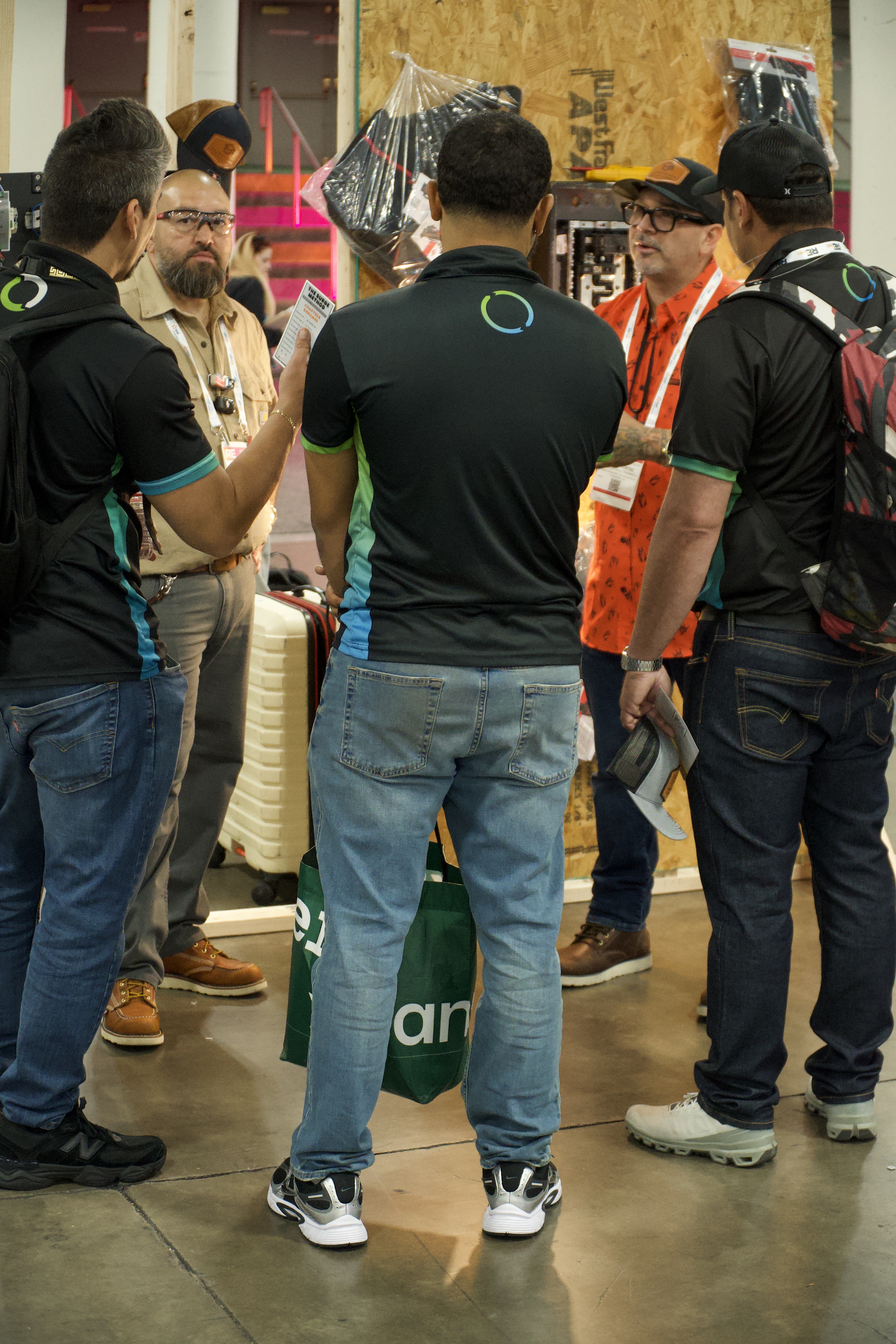 Participants discussing an electrical demonstration beside a training display